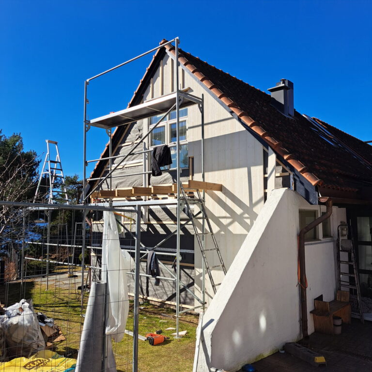 Stillas ved gavlveggen på en bolig under utvendig arbeid